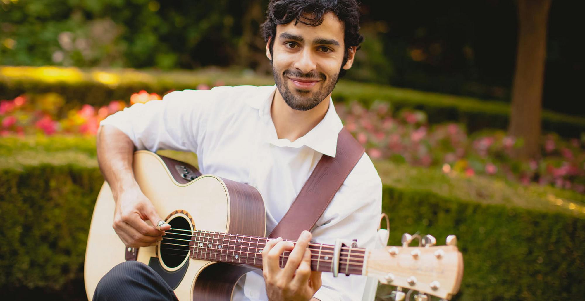 Maneli Jamal playing the guitar.